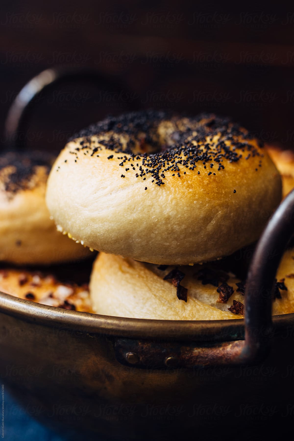 Freshly baked bagels in a brass bowl