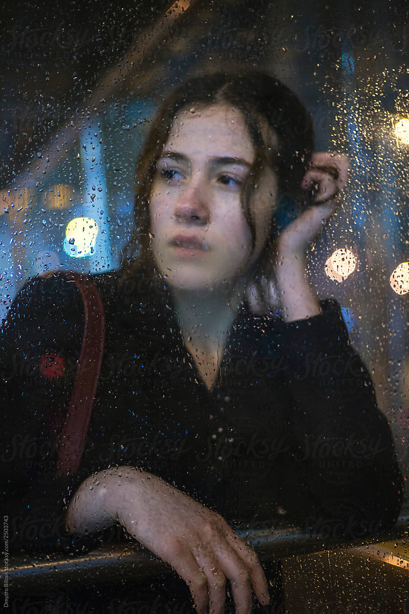 portrait of girl at the bus stop during the rain