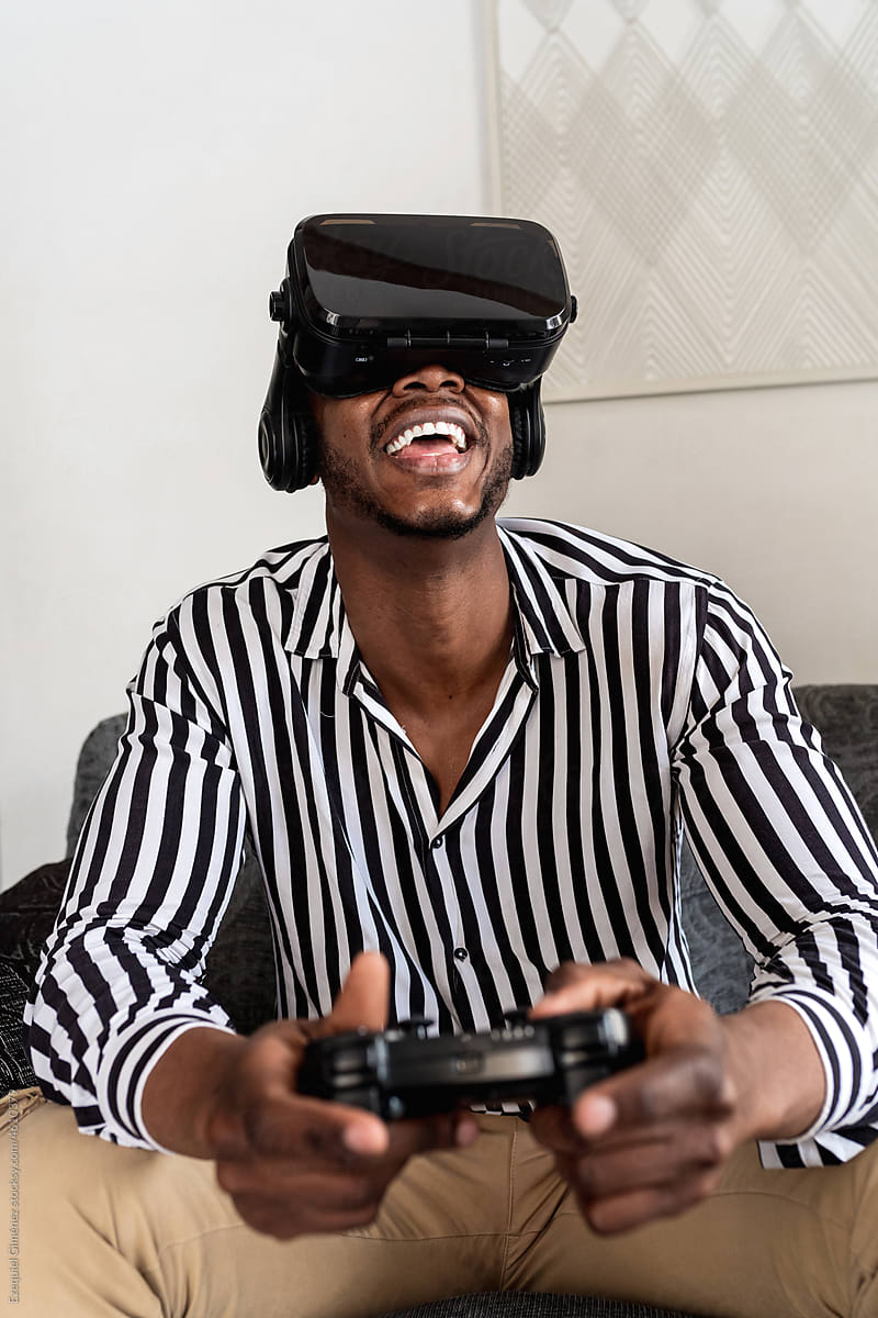 Excited African American gamer in VR goggles