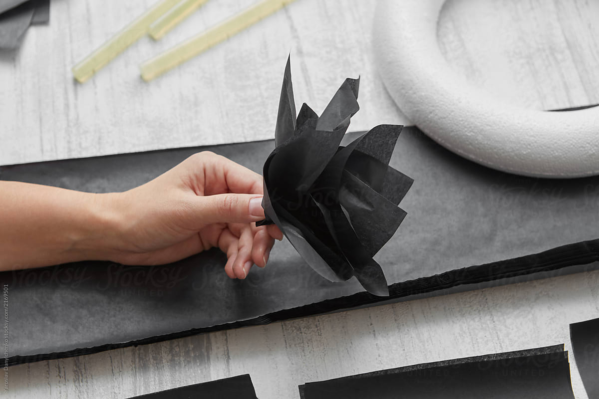 Female hand holds a black paper flower for handcraft