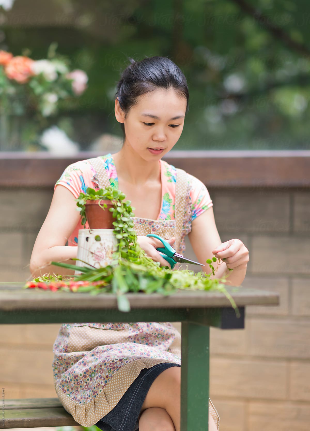 Young woman trimming plants in garden