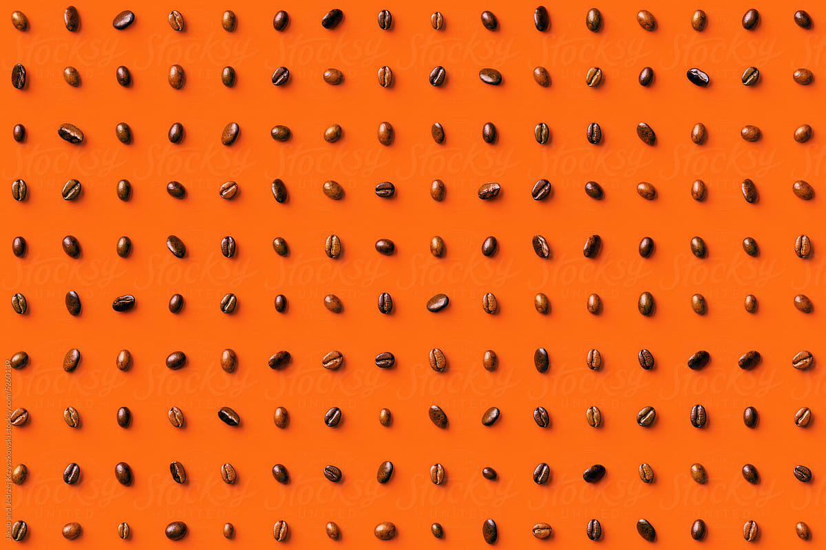 Roasted coffee beans on an orange background
