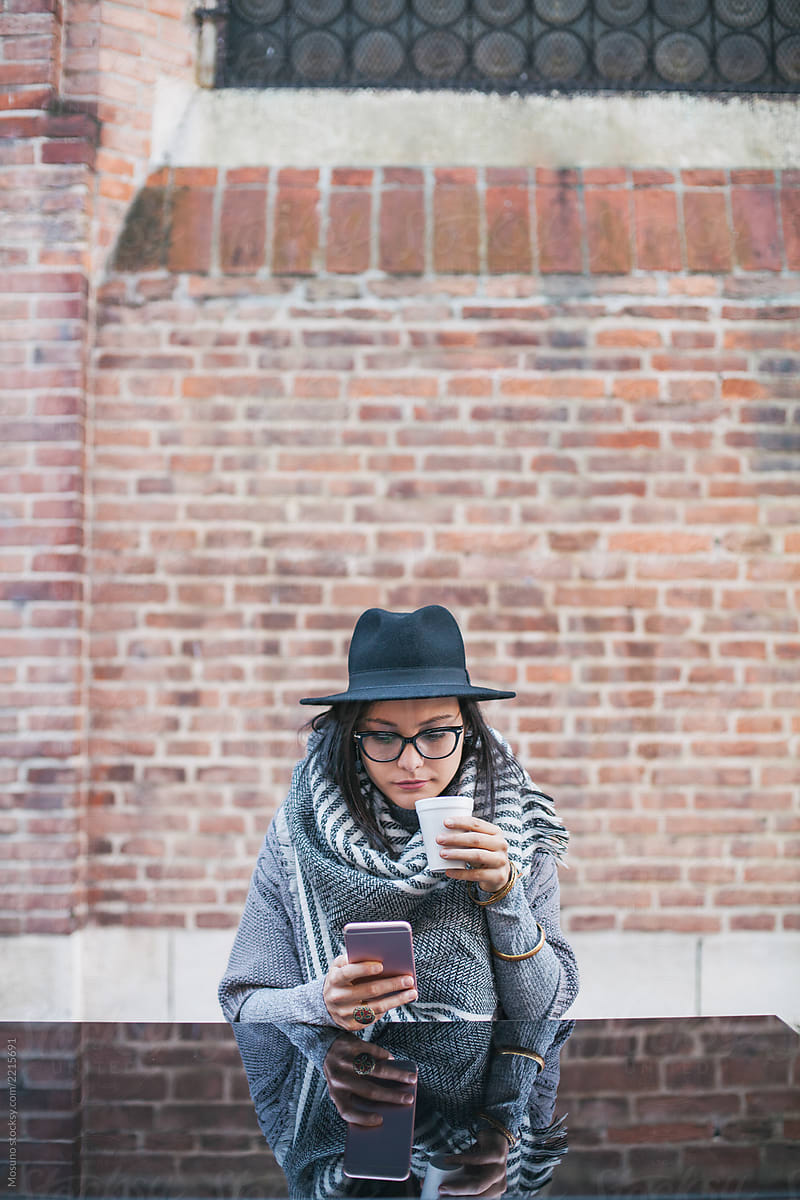 Beautiful woman with a hat looking at her smartphone