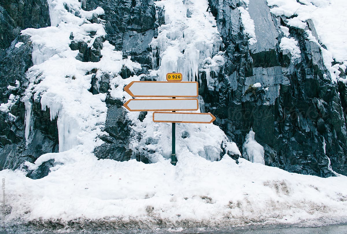 Road signs pointing all directions on a snowy crossing.