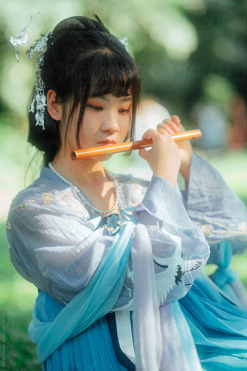 Asian teenage girl playing bamboo flute
