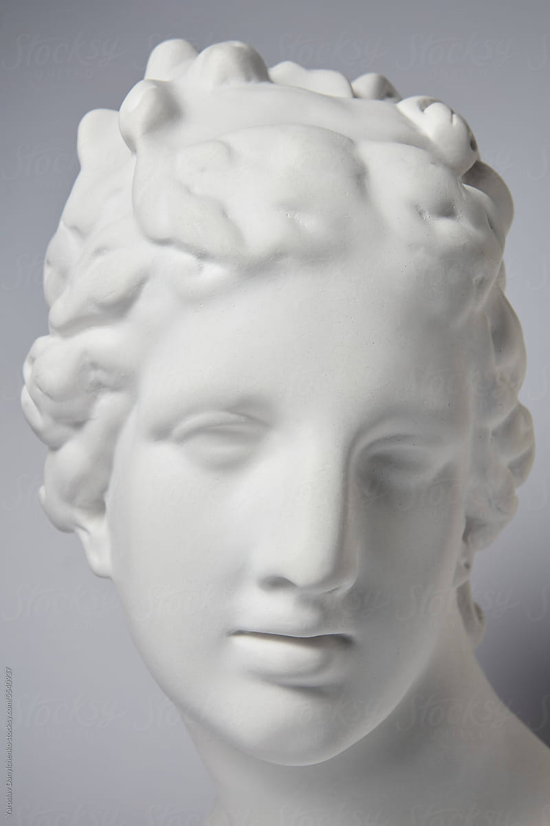 Gypsum sculpture head against gray background.