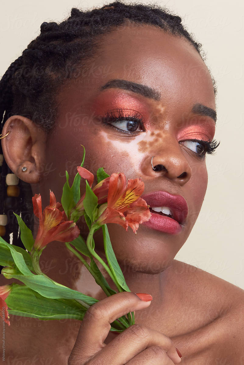 Peaceful Young Black Woman Model Holding Flowers and Gazing Off Screen