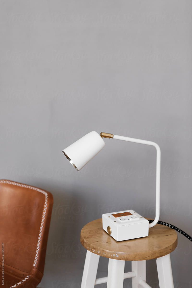 modern white lamp on stool against grey wall