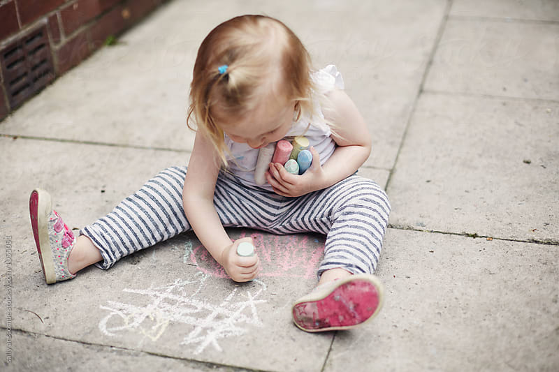 Child drawing with chalk on the floor