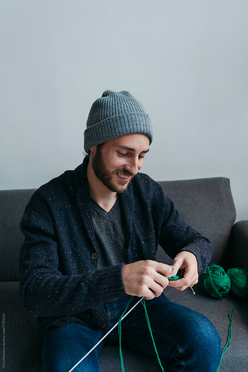 Positive knitter young adult man.