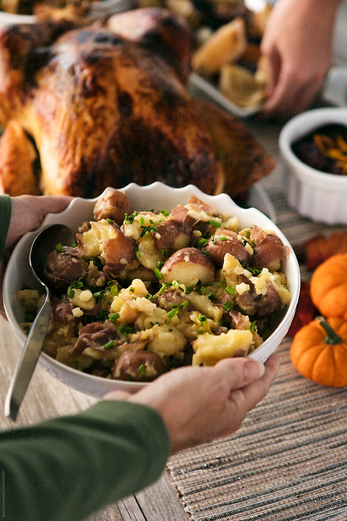Thanksgiving: Woman Puts Bowl Of Smashed Potatoes On Table