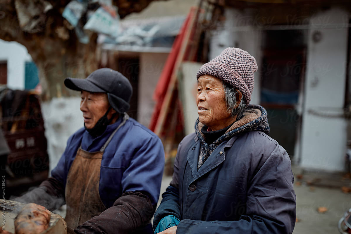 Older Chinese sweet potato vendors at a local market