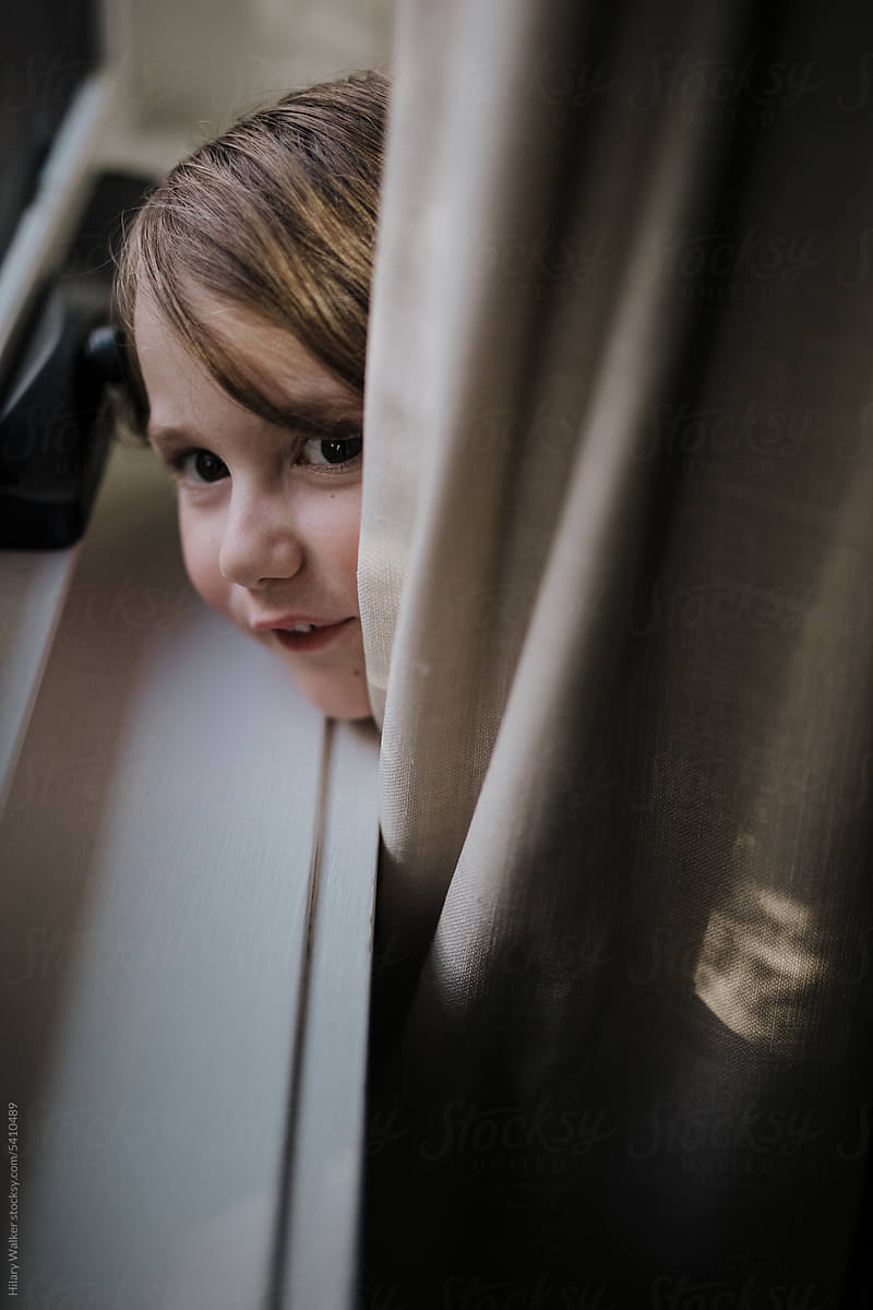Child hiding in curtain
