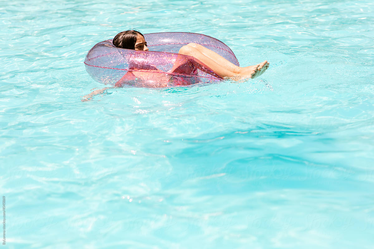 Teen lounging on float in water