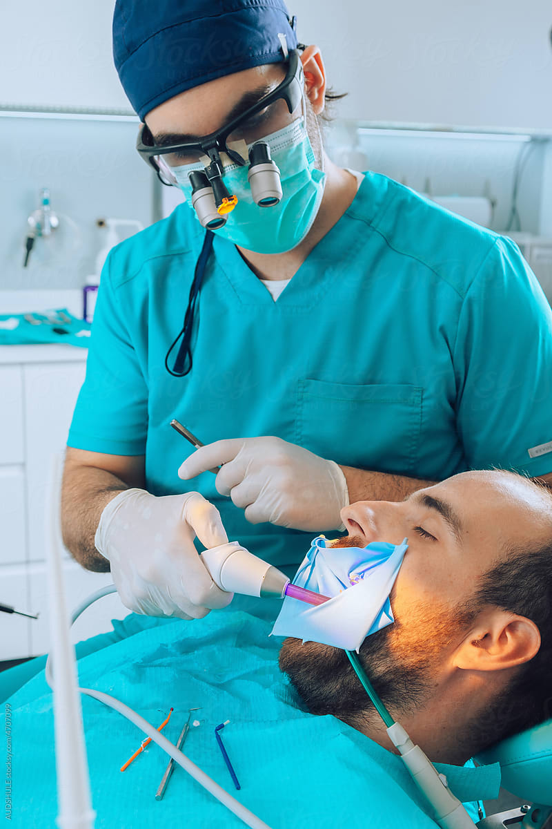 Dental Surgeon Making New Tooth filling with UV light