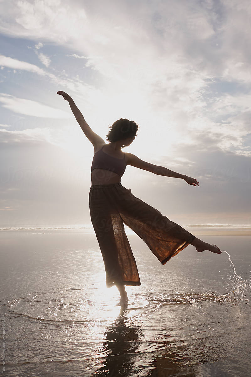 Young girl dancing on the shore of the Atlantic Ocean