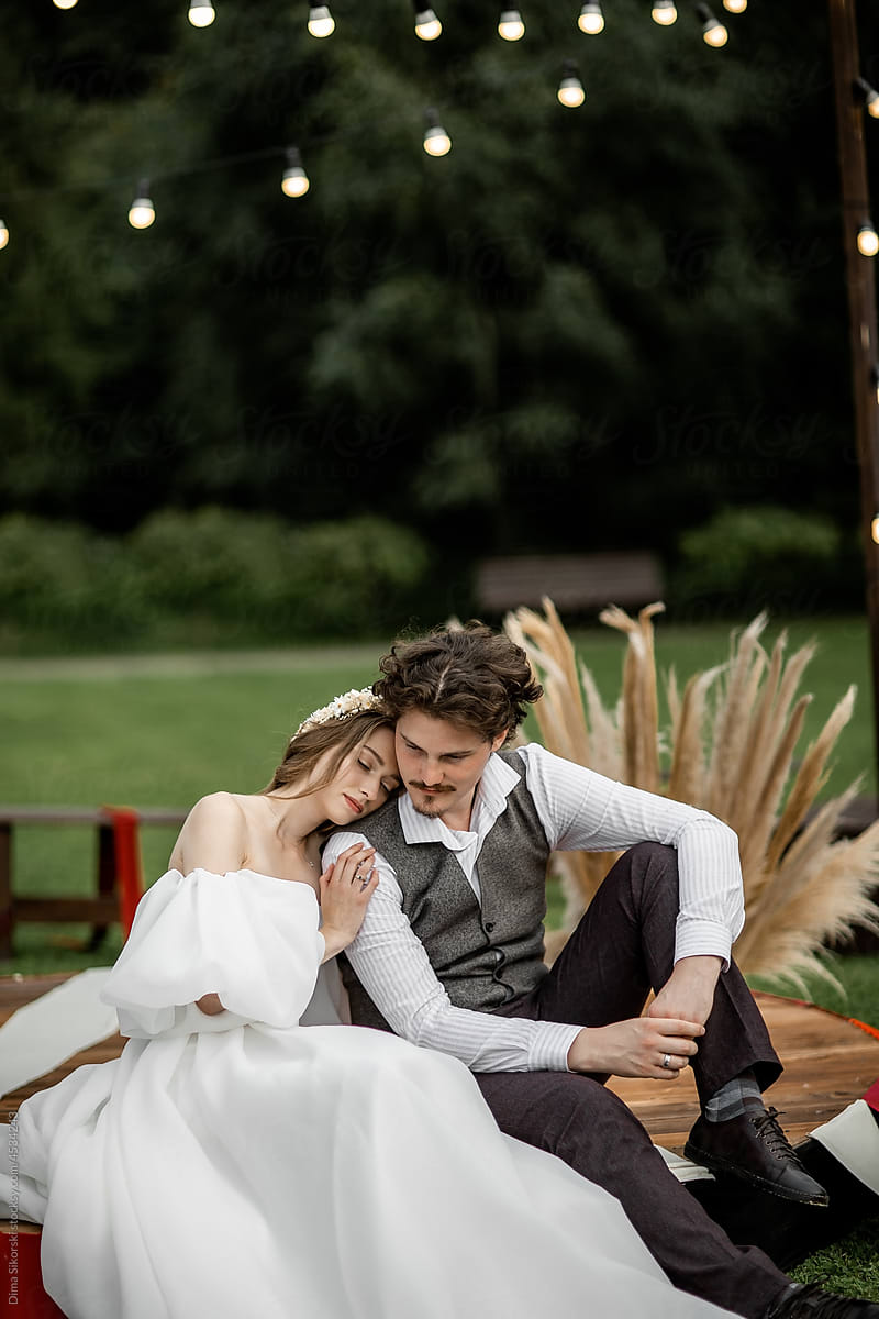 An elegant bride with a curly-haired groom at a rustic wedding