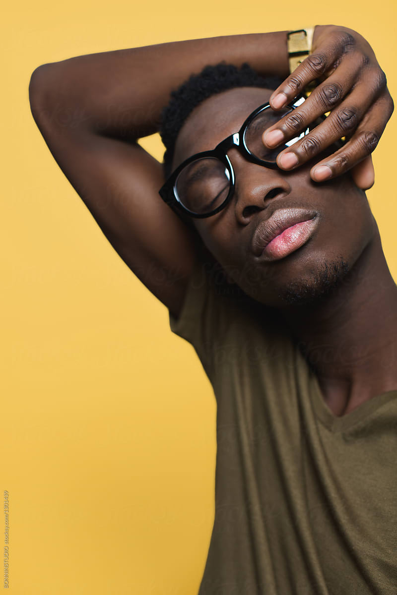 Portrait of a young cool man over yellow background.