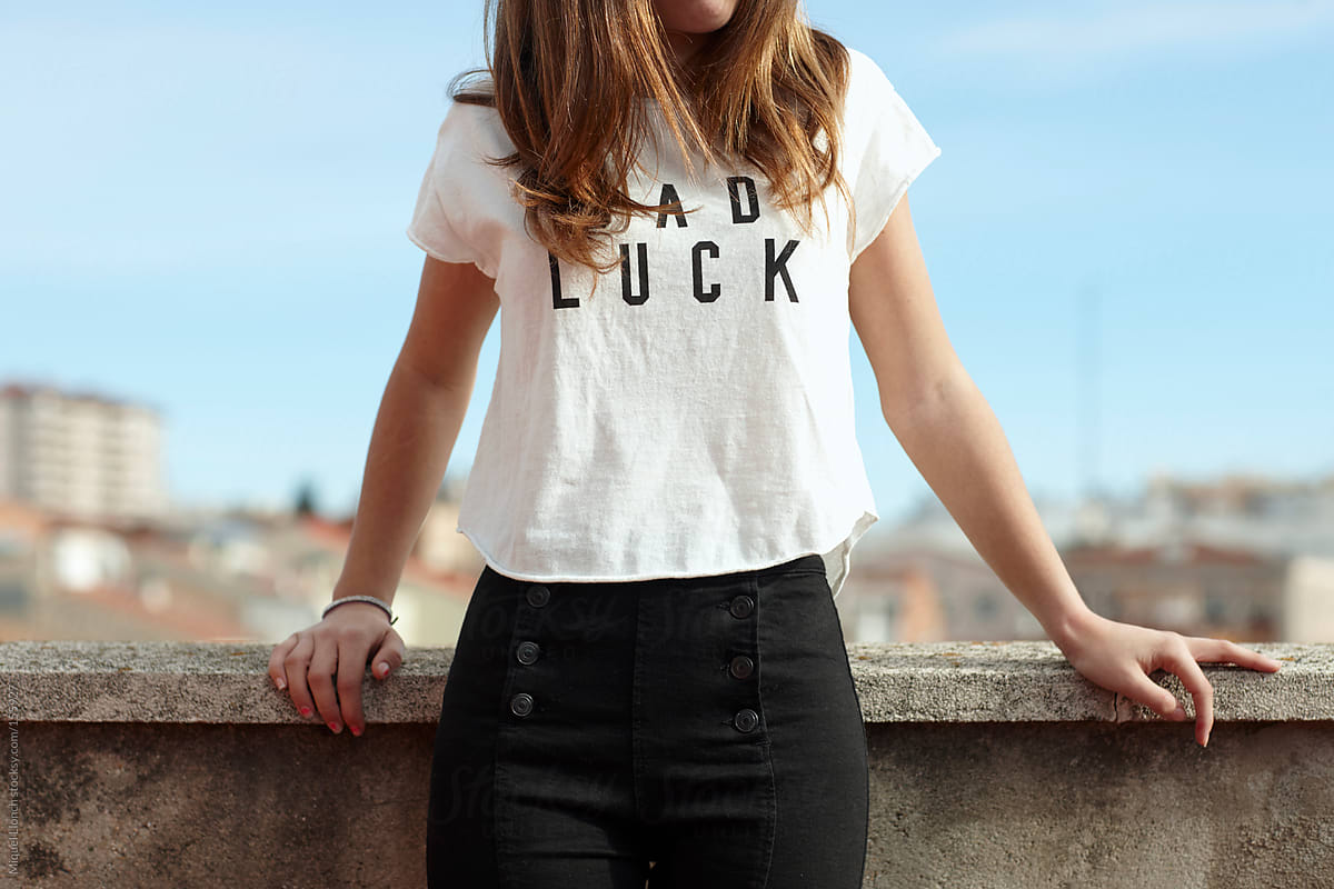 Young female\'s torso  wearing t-shirt featuring  the words BAD LUCK