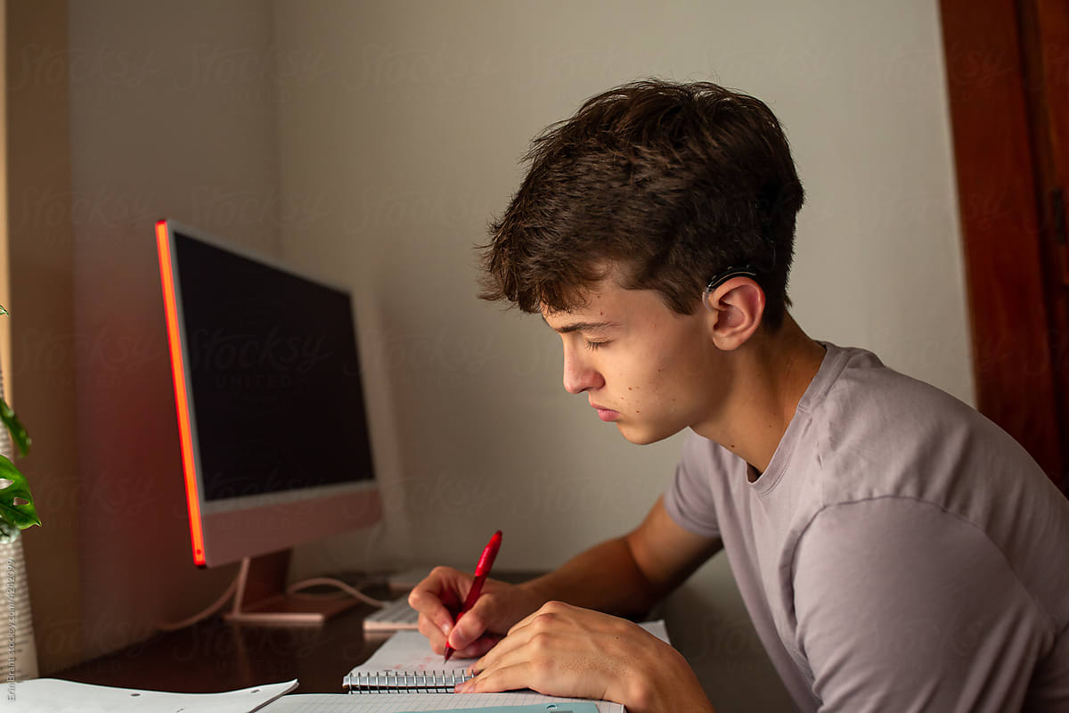Teen boy at desk with eyes closed
