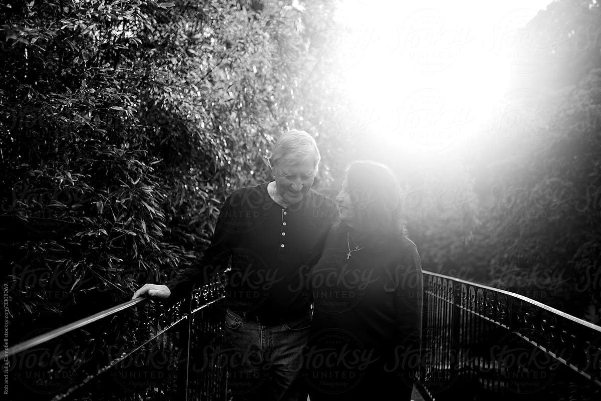 Affectionate older couple spending time walking together in a pa