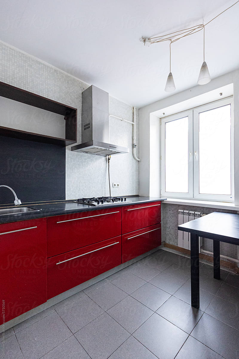 Modern kitchen with red cabinet and natural light coming from window