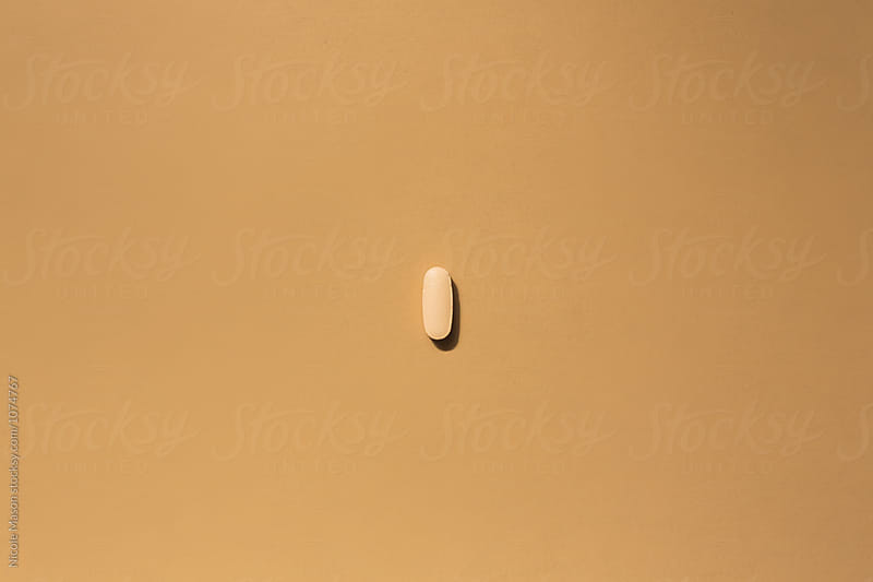 one orange pill on orange surface