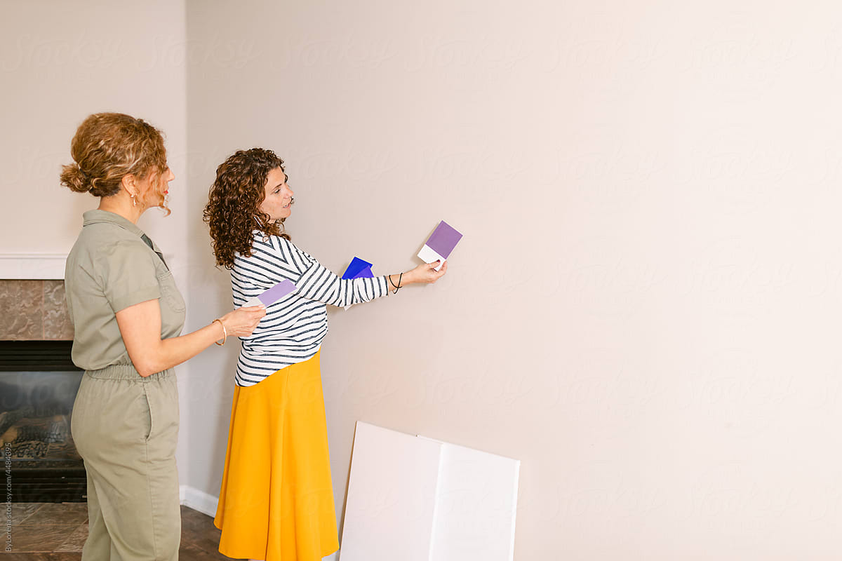 Colleagues choosing accent wall color at empty house