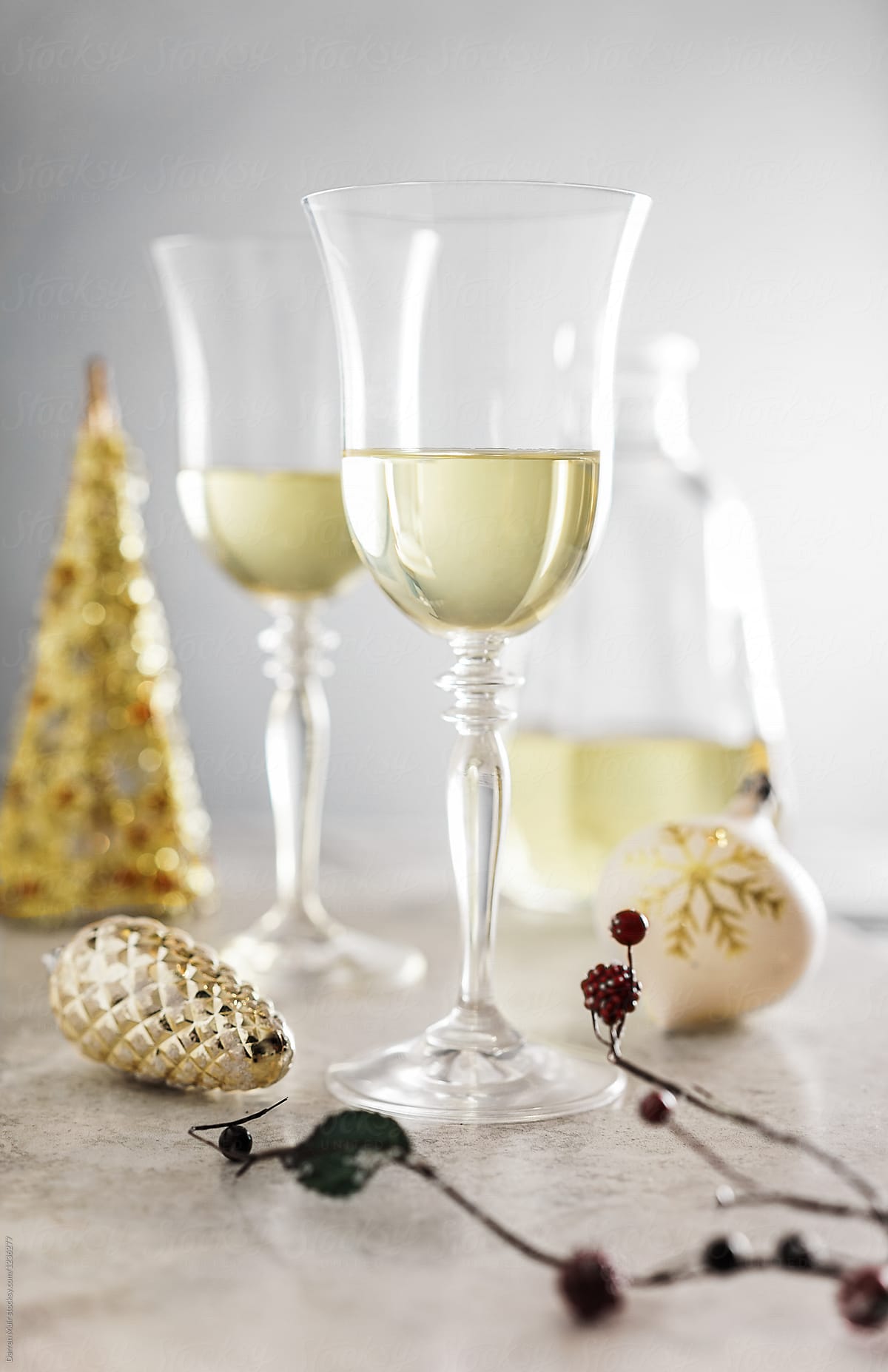 Two glasses of white wine in a festive setting.