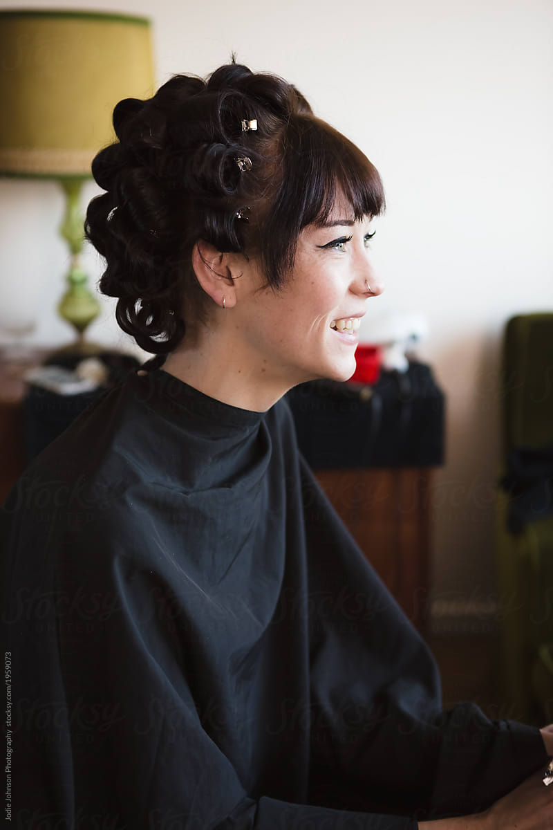 Smiling young woman with rollers in her hair