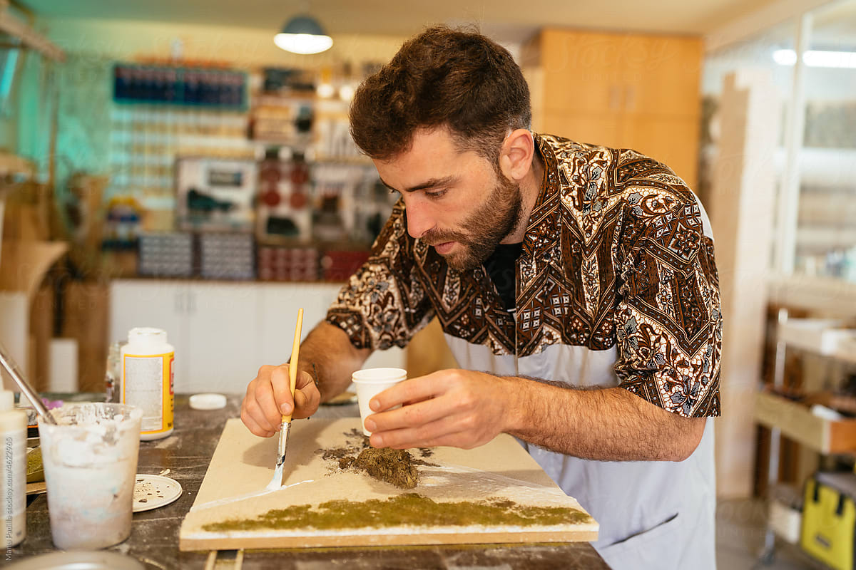 Attentive male artist creating resin art in workshop