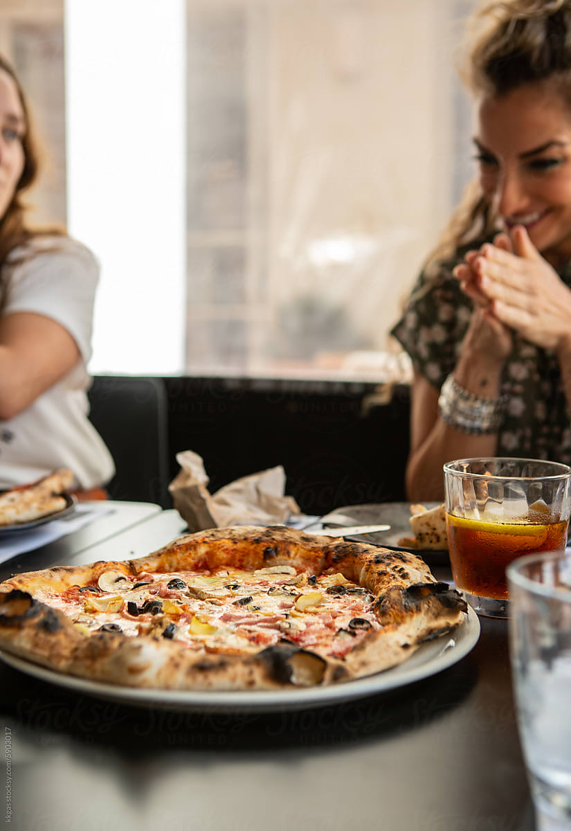 Delighted woman waits to eat pizza