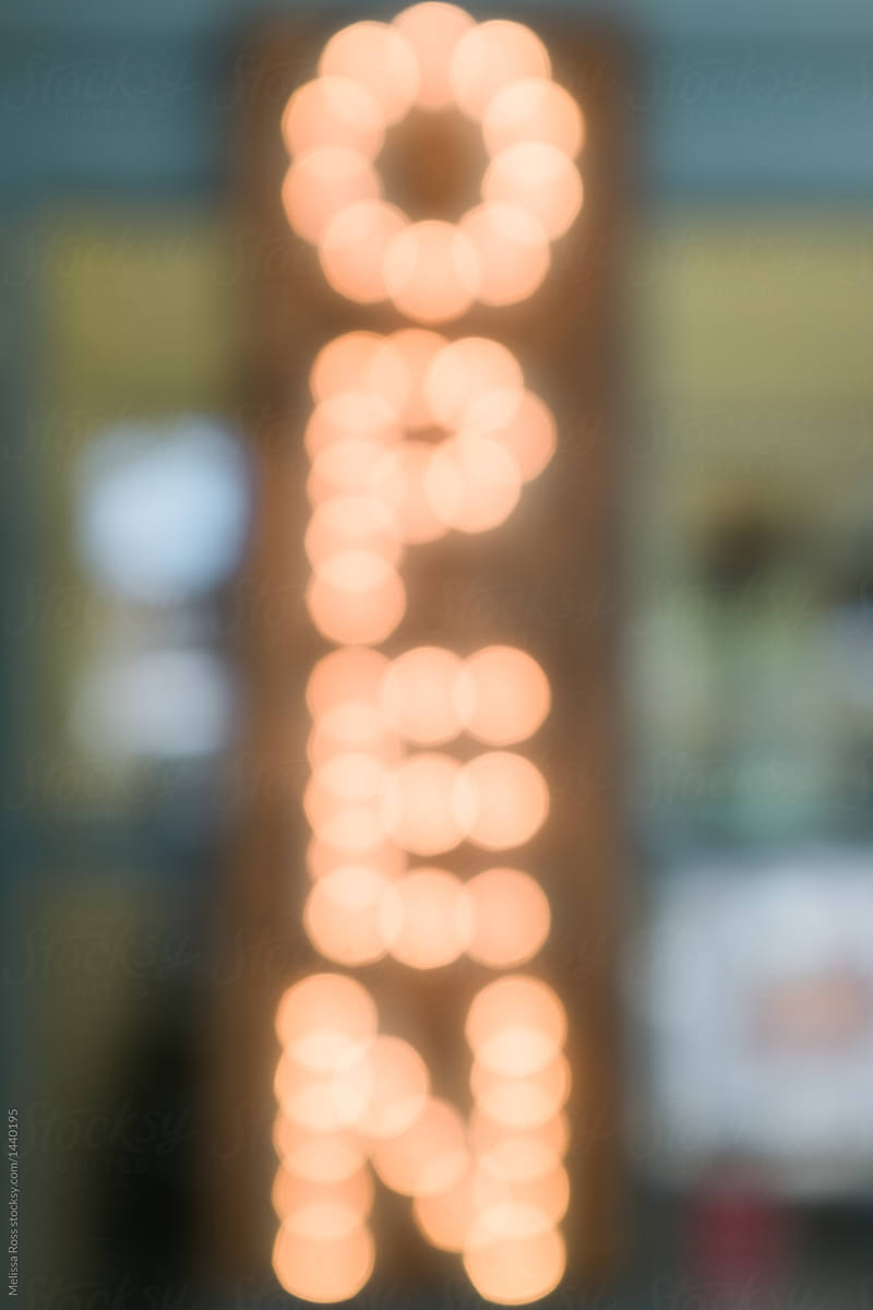 Blurred light up open sign on a storefront door.
