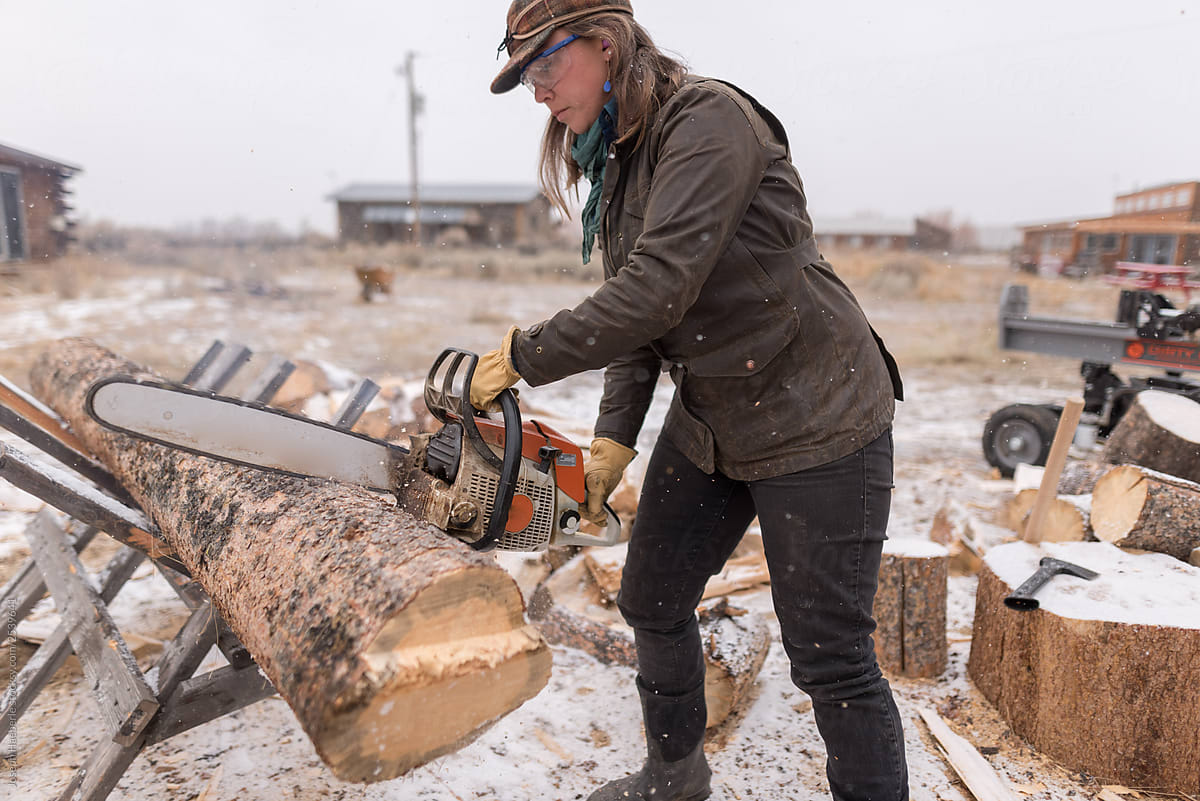 Ranch Manager and Cowgirl Kelsey cutting wood with a chainsaw