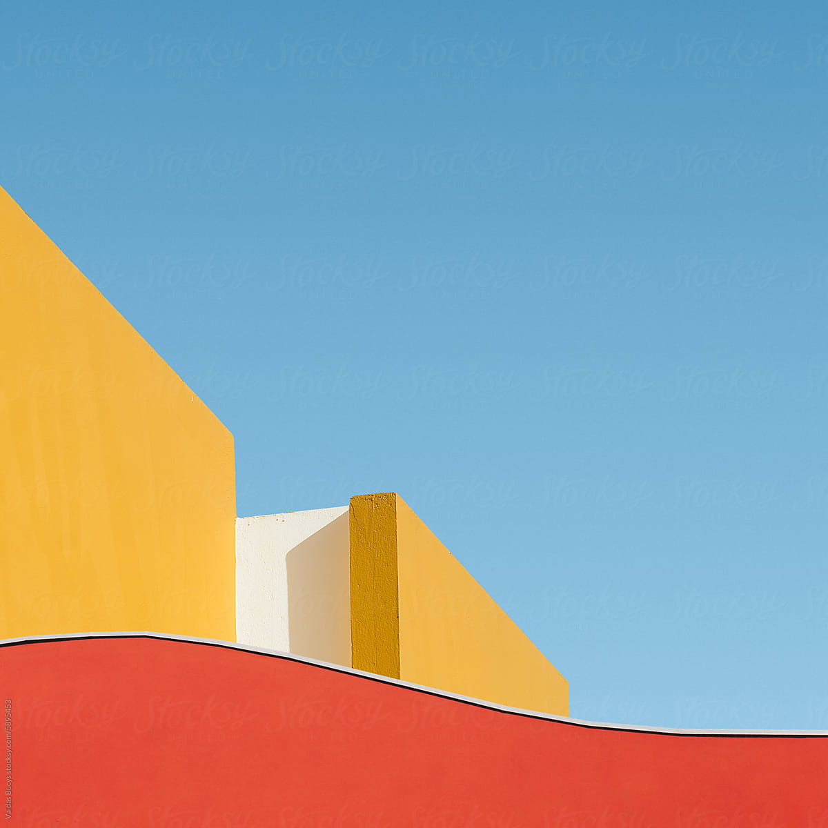 Colorful geometric shape of building wall against blue sky
