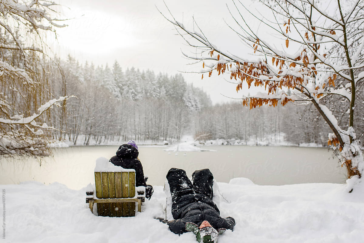 Couple sitting by a frozen lake