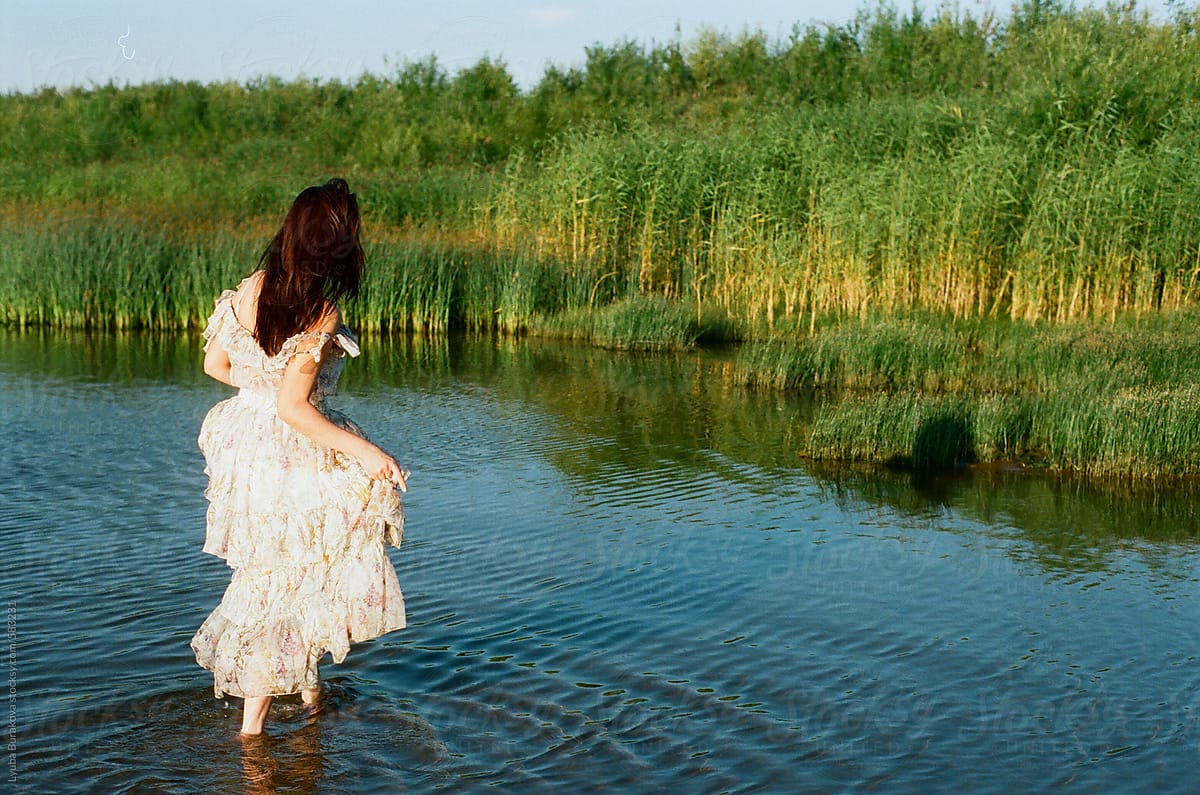 Woman Walking Away In The Water Of The Lake Del Colaborador De Stocksy Amor Burakova Stocksy 0347