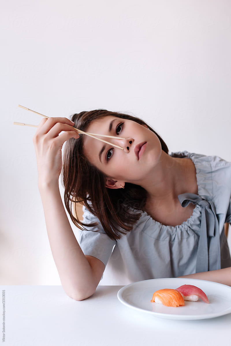 Concept portrait of young asian woman eating sushi