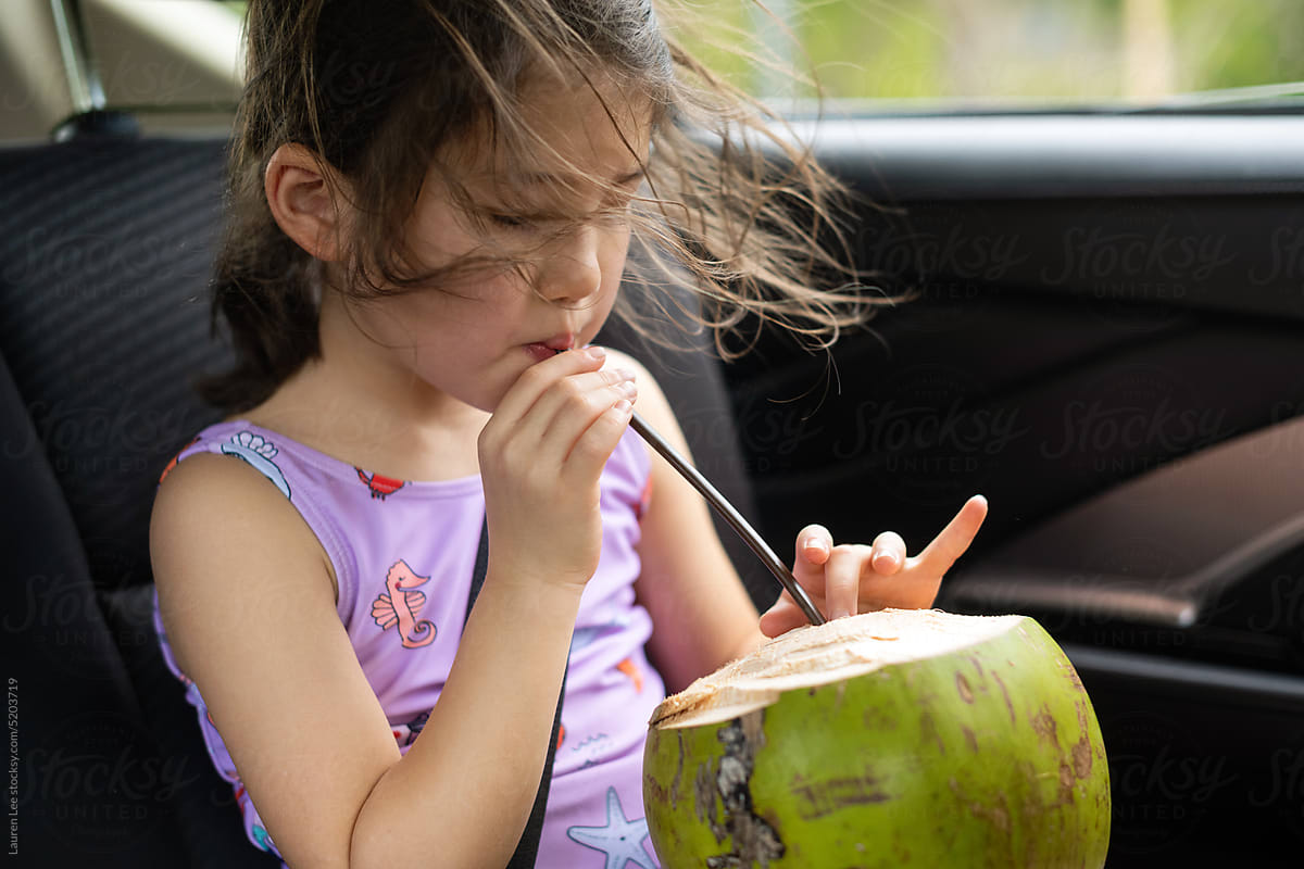 Little kid drinking straight from a coconut