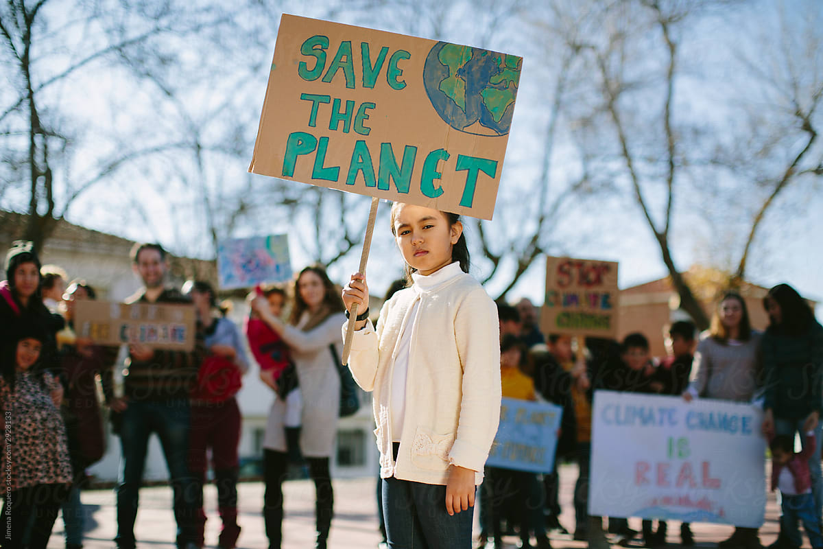 Young girl carrying a banner claiming to save the planet