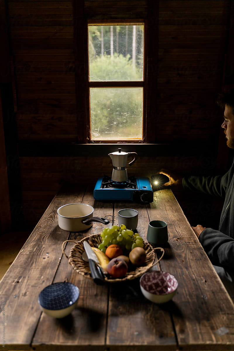 Man making coffe at cozy wooden cabin