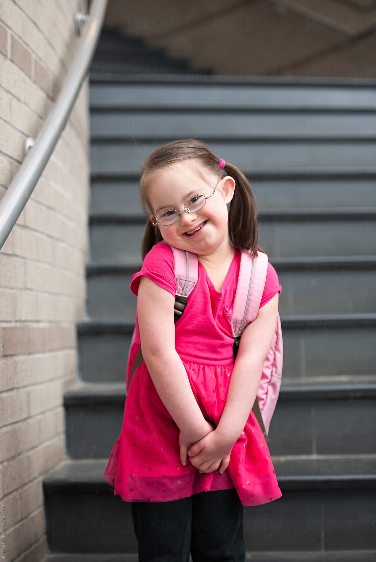 Exuberant Little Girl With Down Syndrome Smiling In School By Brian Mcentire Stocksy United