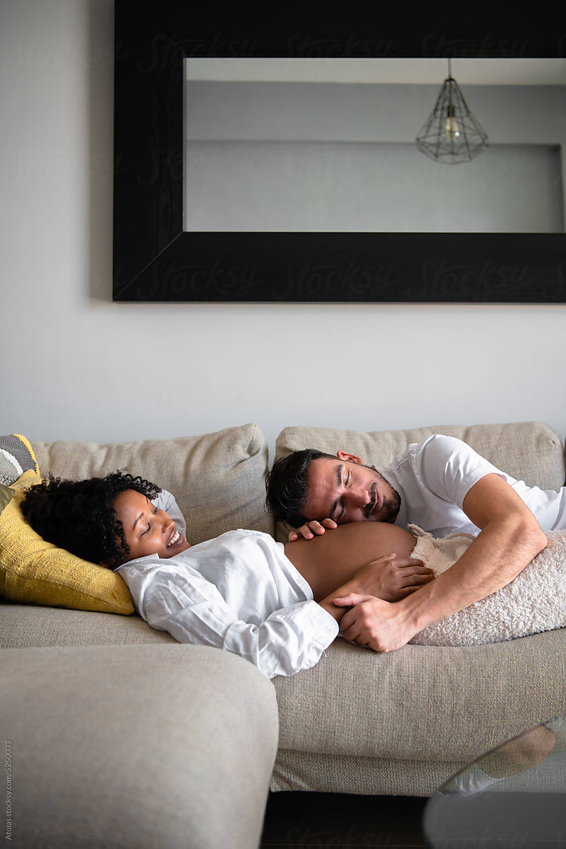 Biracial couple lying on couch