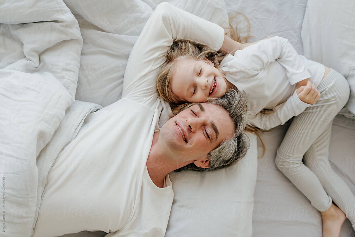 Playful father and daughter on bed