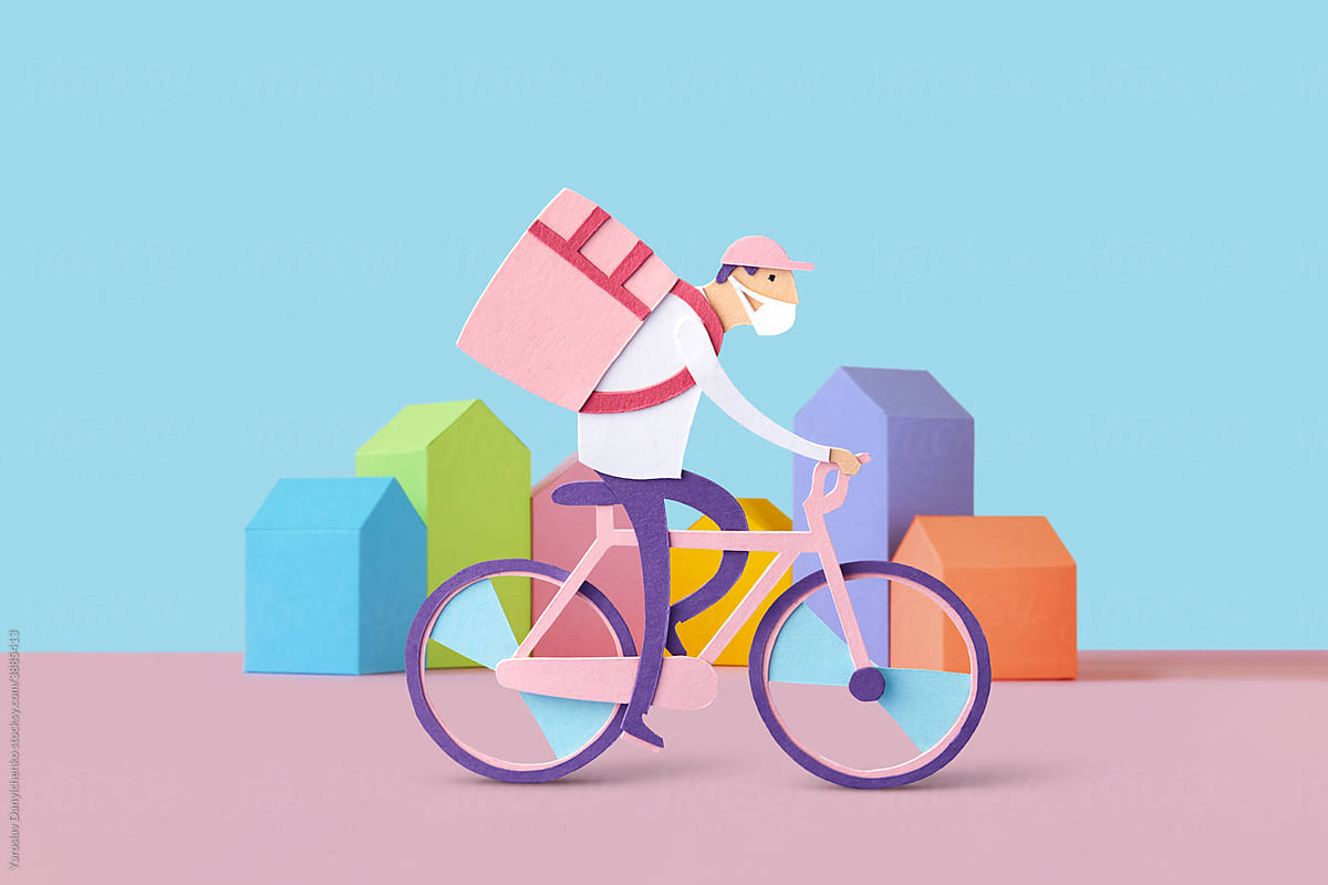 Papercraft courier in mask on bike delivering products