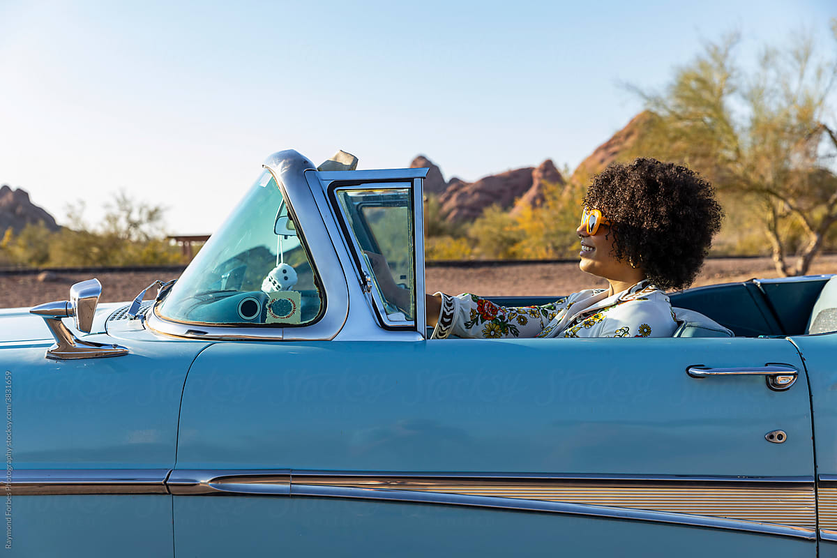 Happy Beautiful Black woman in Vintage Classic Car behind the steering wheel