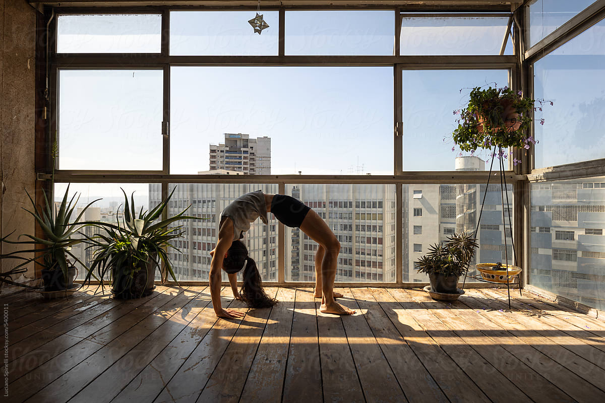 Bridge: yoga pose silhouette against floor-to-ceiling panoramic window