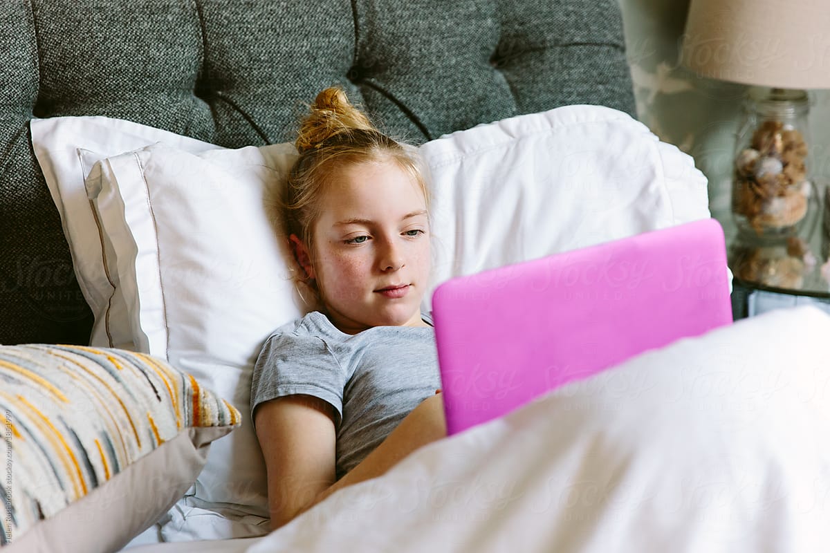Preteen Girl Streaming A Tv Programme On Her Laptop In Bed By Helen