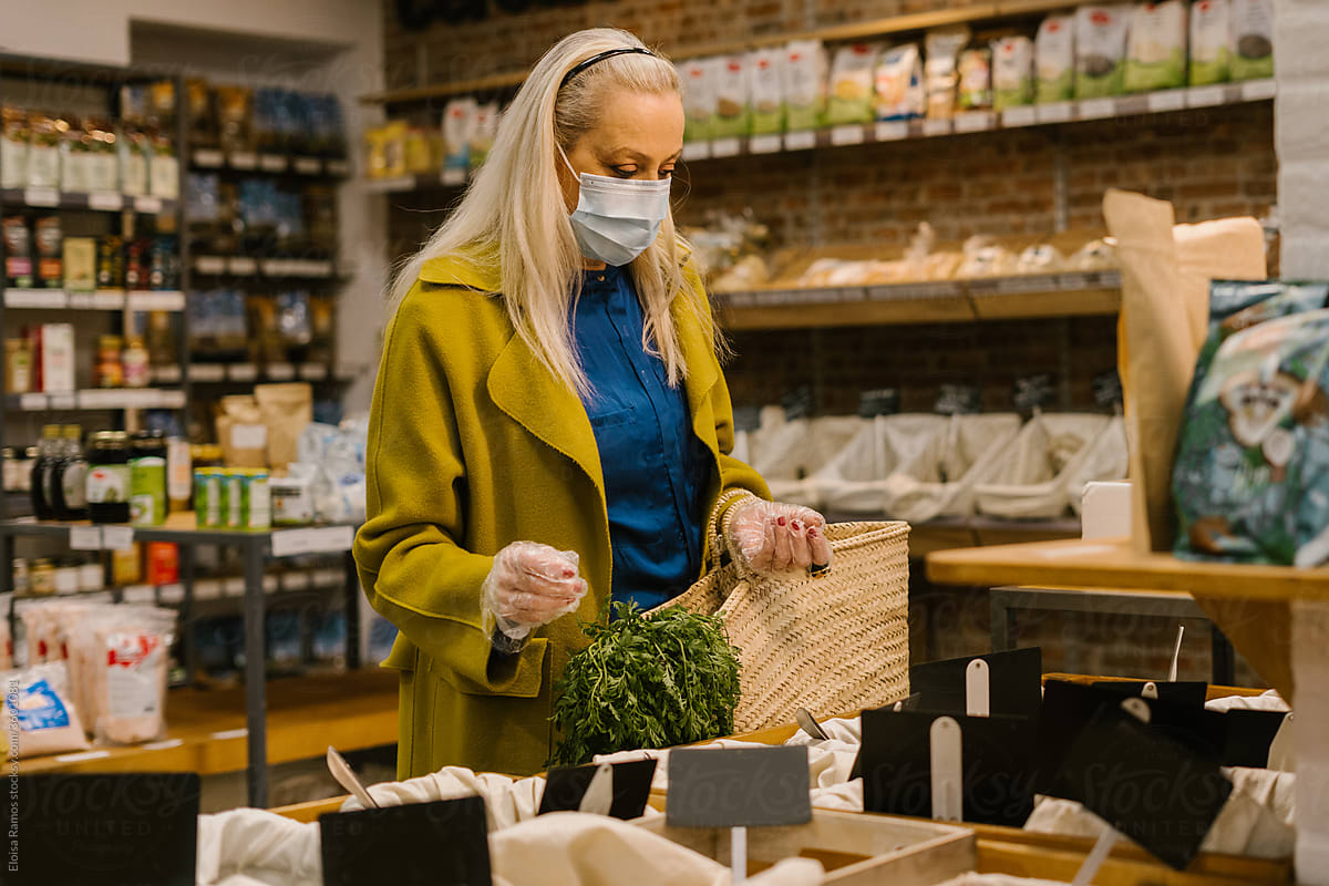 Senior woman with mask shopping at vegan market