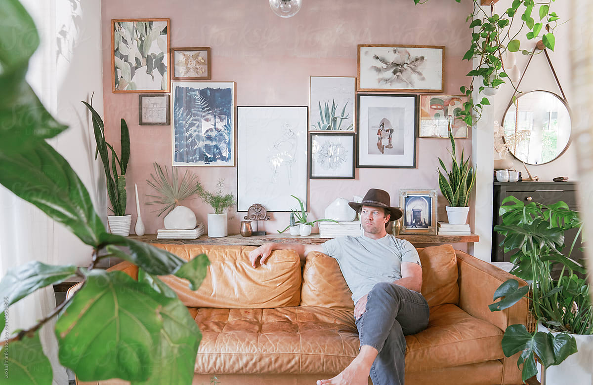 man relaxes on couch in modern bohemian home